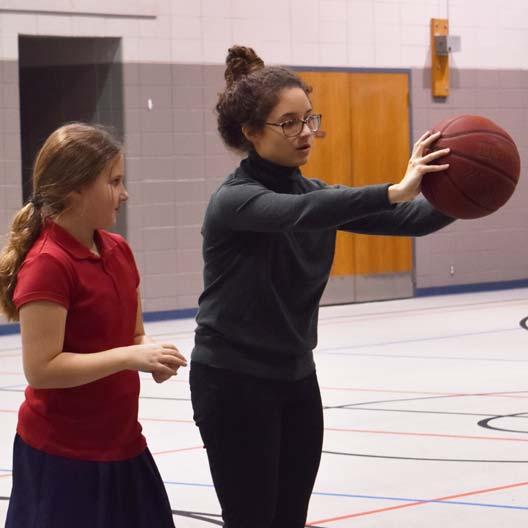 一名学生在小学教育服务学习体育课上打篮球